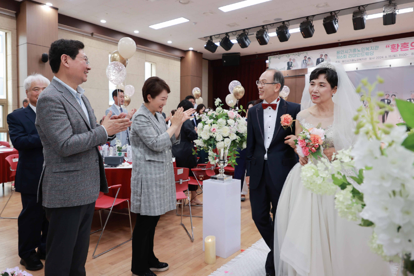 2-2. 이상일 용인특례시장이 15일 기흥노인복지관에서 열린 리마인드 웨딩 행사에서 행진하는 어르신 부부에게 축하 인사를 건네고 있다.JPG