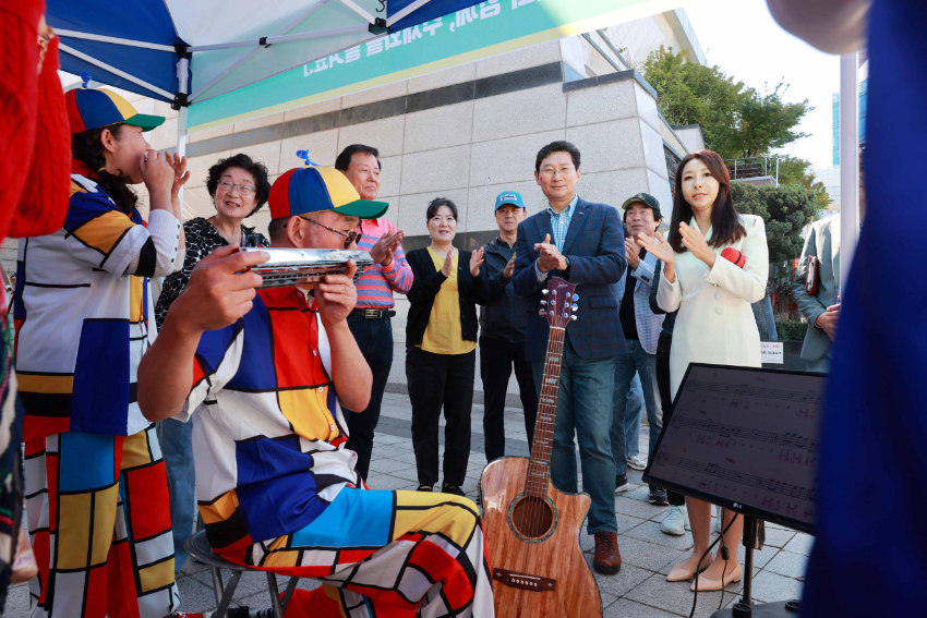 8-6. 이상일 용인특례시장이 3일 동백호수공원에서 열린 2024 용인시 주민자치 박람회에서 기흥구 영덕1동의 하모니카 공연을 관람하고 있다.JPG
