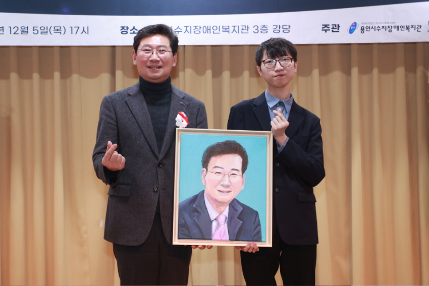 6-2. 이상일 용인특례시장이 직접 그린 그림을 선물한 홍기현씨와 기념 촬영하고 있다.jpg