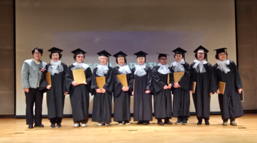 6-2. 용인특례시 성인문해학교 수지교실 졸업생 9명이 졸업장을 들고 기념촬영 하고 있다.jpeg